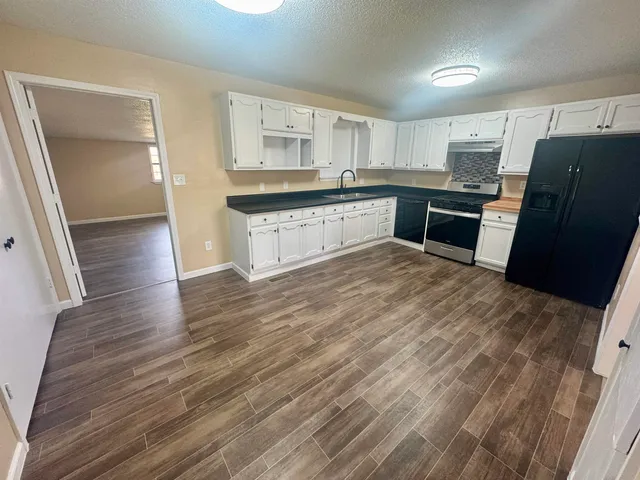 a kitchen with wooden floors and white appliances