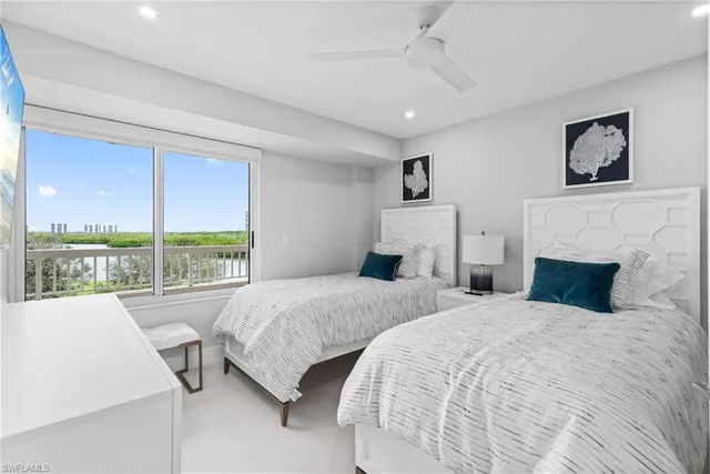 a bedroom with two large bed and a large window