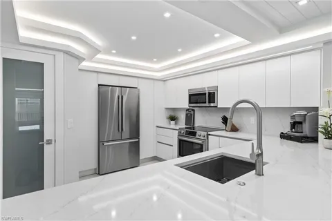 a kitchen with stainless steel appliances granite countertop a refrigerator and a stove top oven