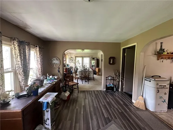 a open kitchen with stainless steel appliances kitchen island granite countertop a sink dishwasher stove a microwave oven with a dining table and chairs with wooden floor