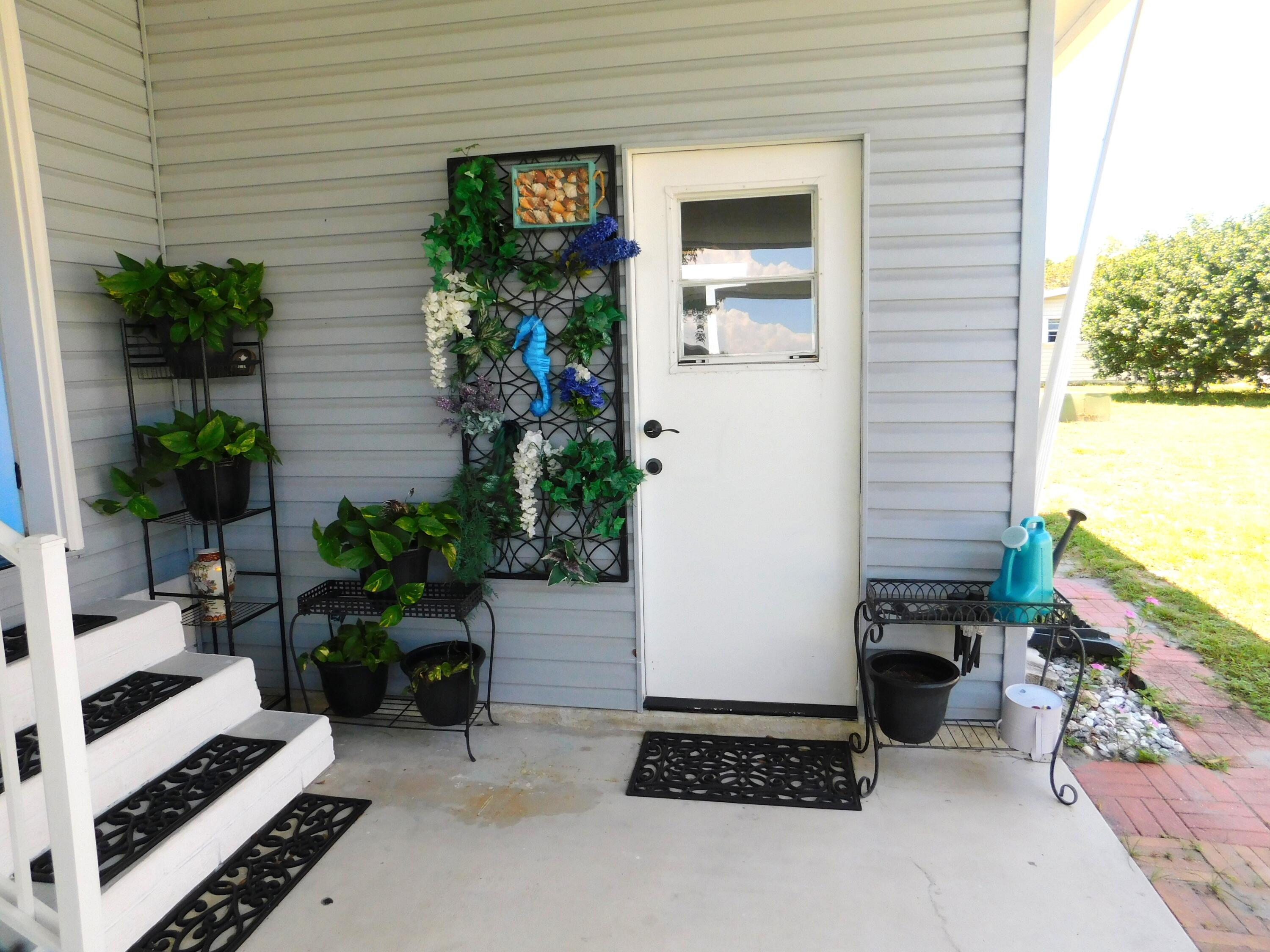 376 Seahorse Terrace Fort Pierce, FL 34982 - Photo 3 of 16 a house with potted plants in front of door