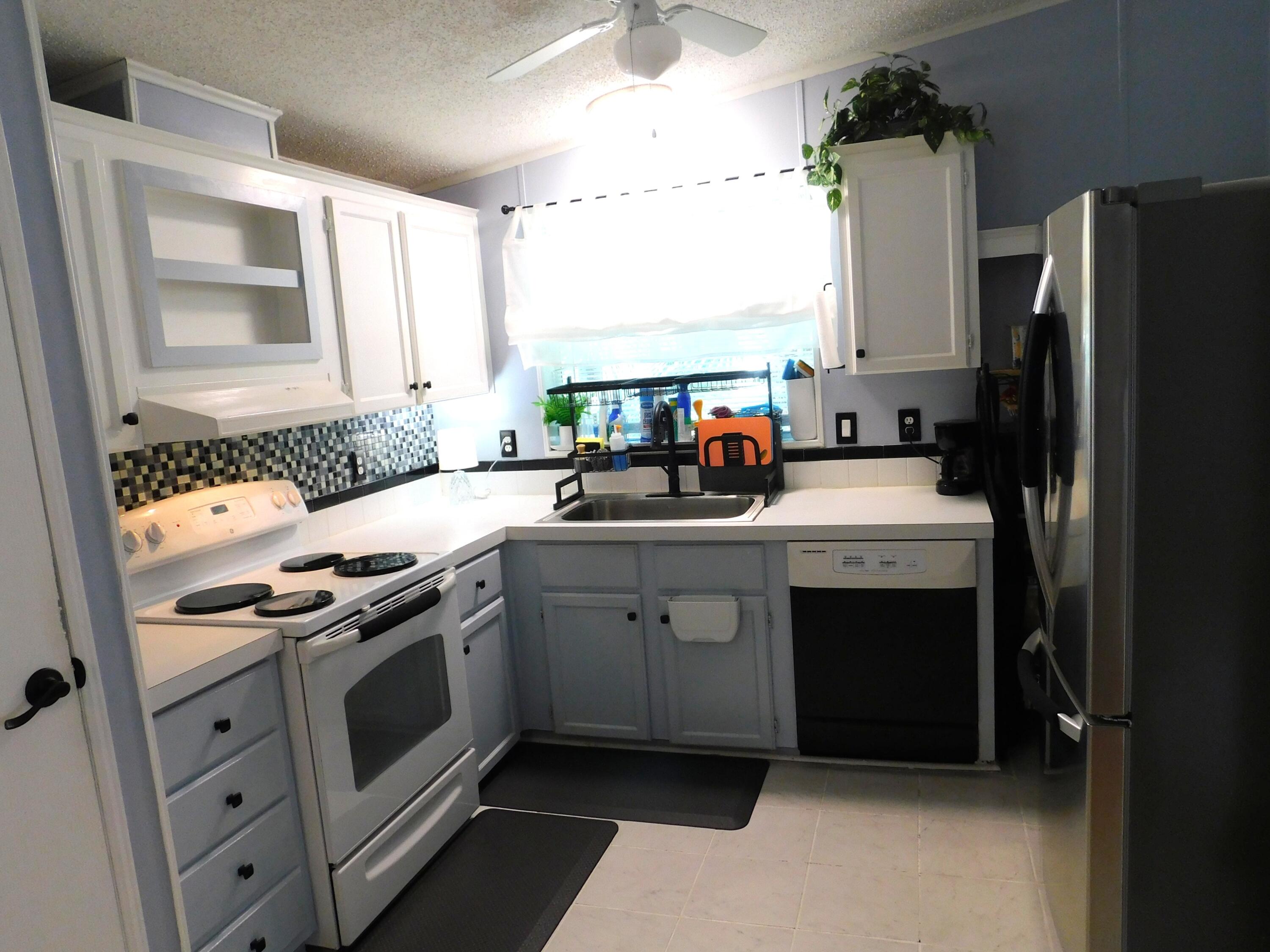 376 Seahorse Terrace Fort Pierce, FL 34982 - Photo 5 of 16 a kitchen with white cabinets and white appliances