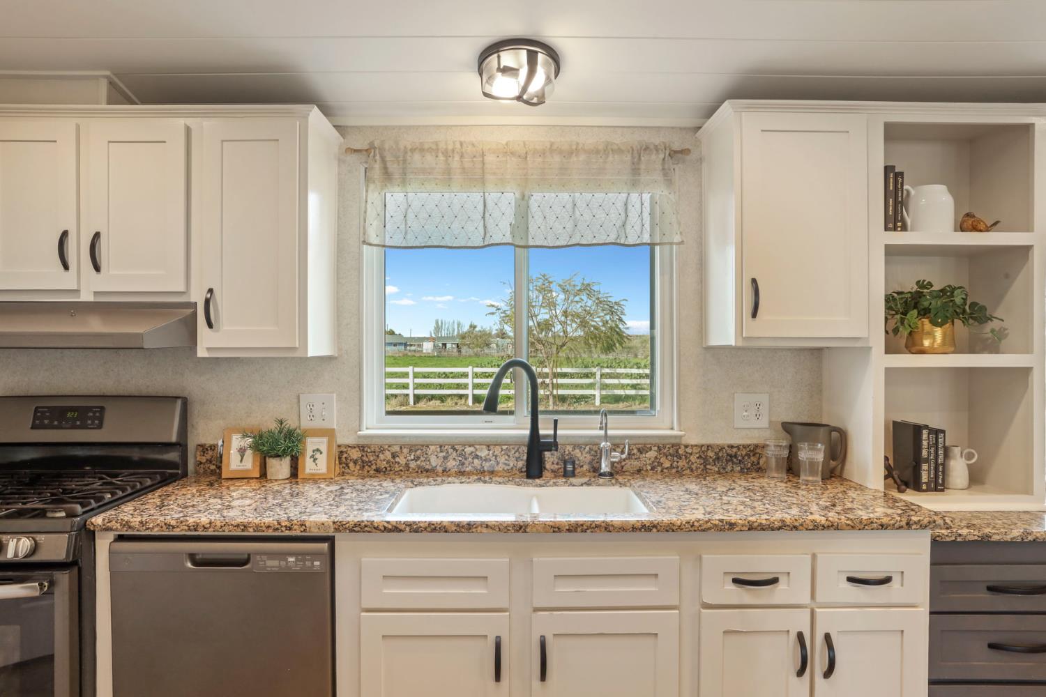 3320 Durham Ferry Road Tracy, CA 95304 - Photo 19 of 77 a kitchen with granite countertop a sink window and cabinets