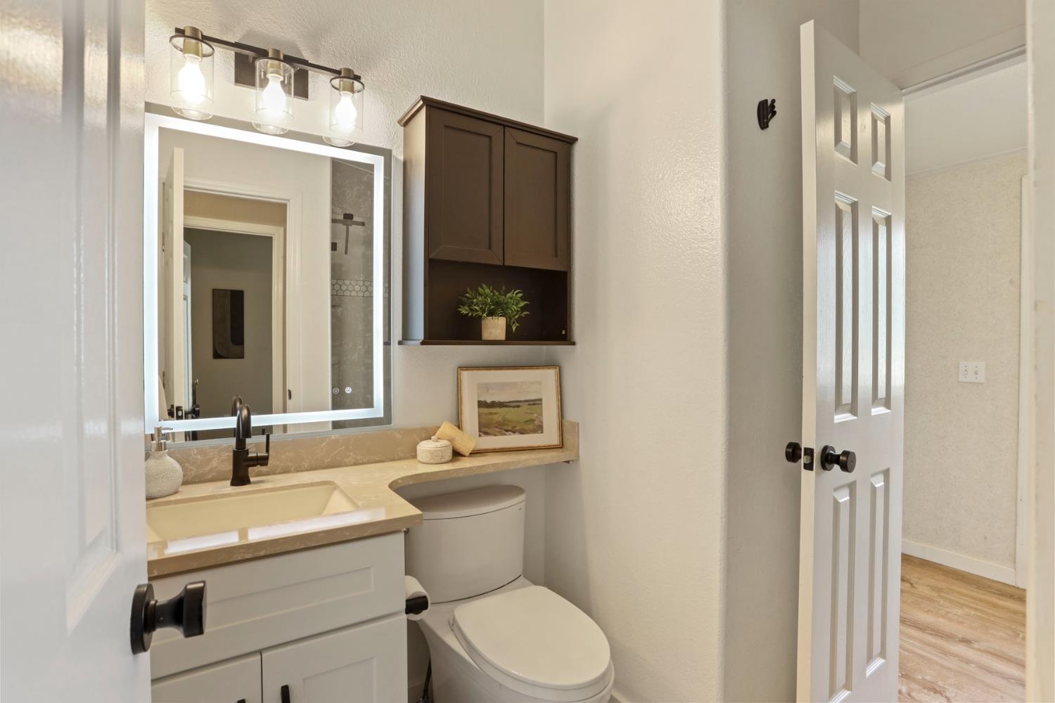 3320 Durham Ferry Road Tracy, CA 95304 - Photo 30 of 77 a bathroom with a toilet a sink and mirror