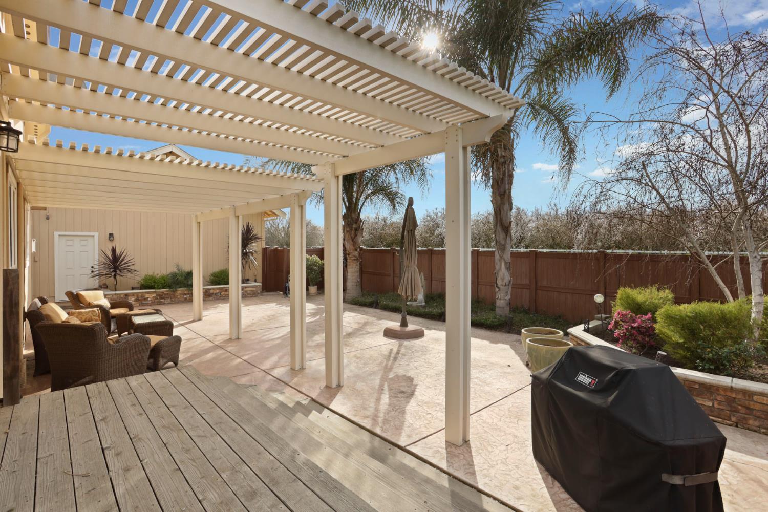 3320 Durham Ferry Road Tracy, CA 95304 - Photo 44 of 77 a view of a patio with table and chairs potted plants with wooden floor and fence