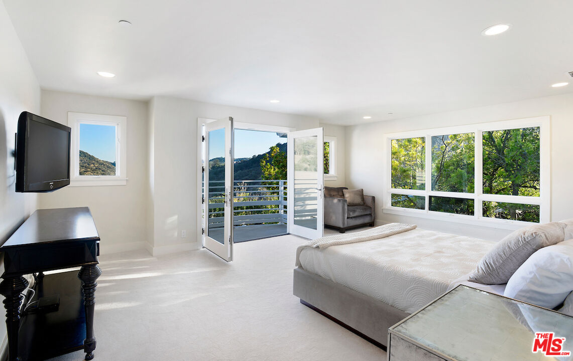 2547 Hutton Drive Beverly Hills, CA 90210 - Photo 12 of 27 a large bedroom with a bed and glass window