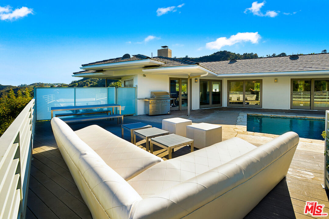 2547 Hutton Drive Beverly Hills, CA 90210 - Photo 23 of 27 a view of a patio with couches table and chairs with wooden floor