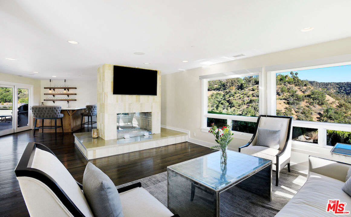 2547 Hutton Drive Beverly Hills, CA 90210 - Photo 5 of 27 a living room with furniture floor to ceiling window hardwood floor and a flat screen tv
