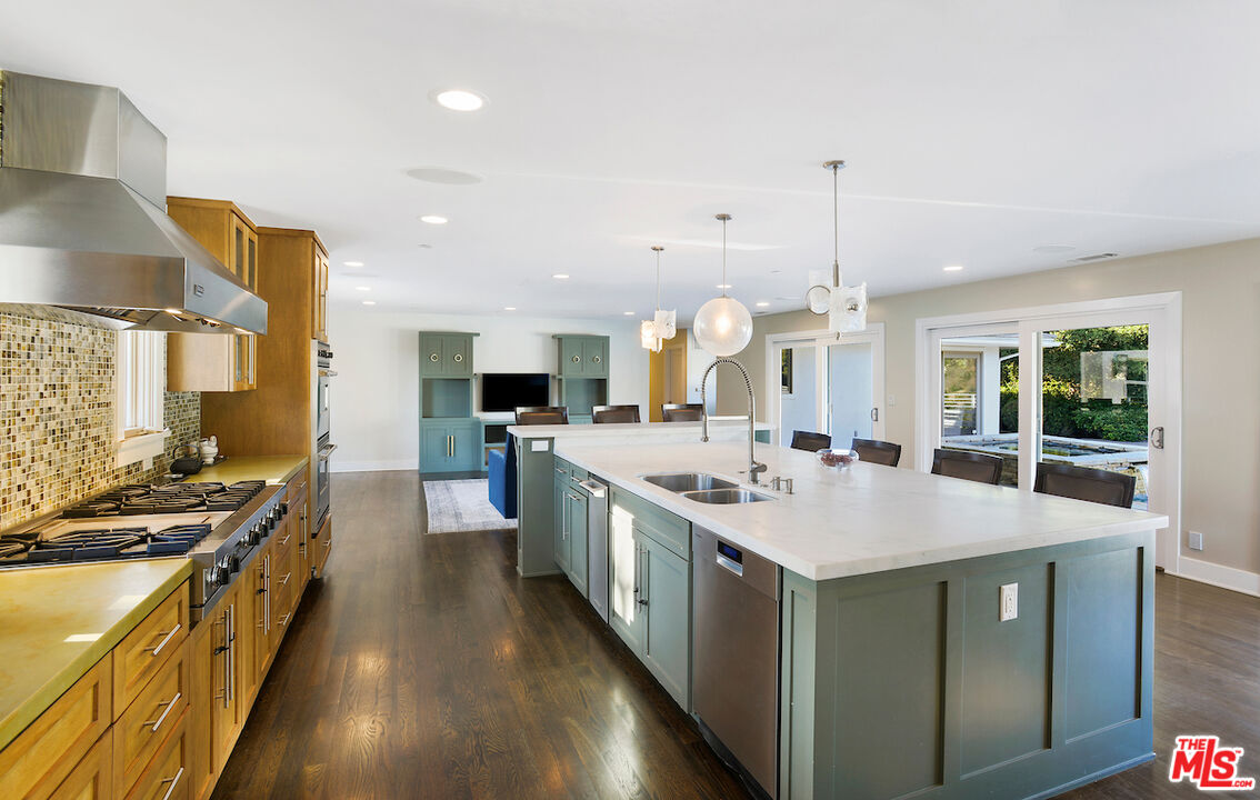 2547 Hutton Drive Beverly Hills, CA 90210 - Photo 7 of 27 a large kitchen with kitchen island a stove a sink a center island and windows