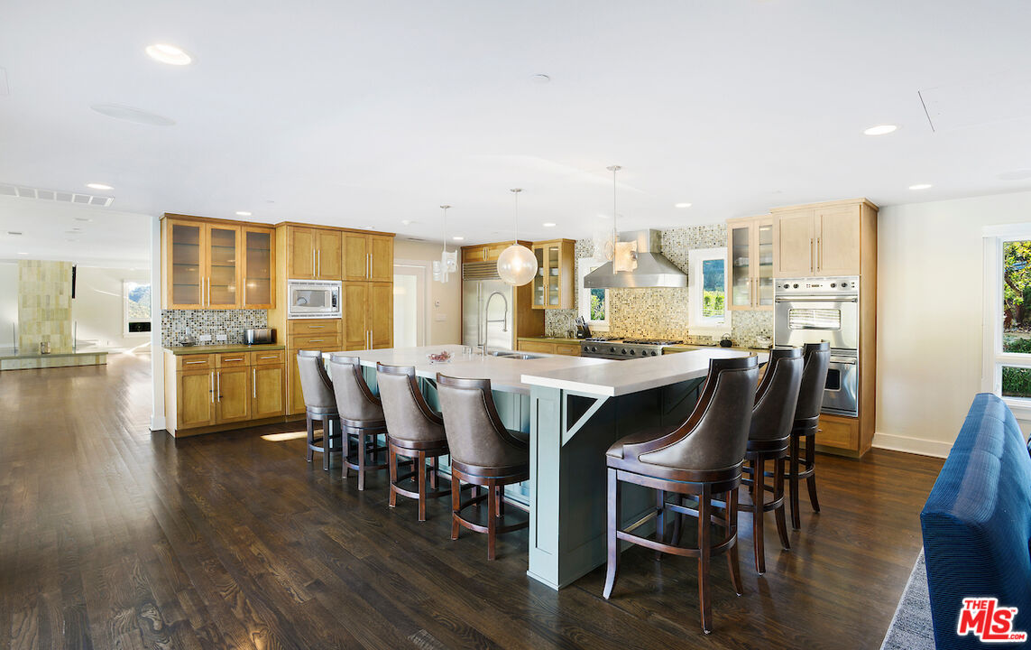 2547 Hutton Drive Beverly Hills, CA 90210 - Photo 8 of 27 a dining room with stainless steel appliances a table and chairs with wooden floor