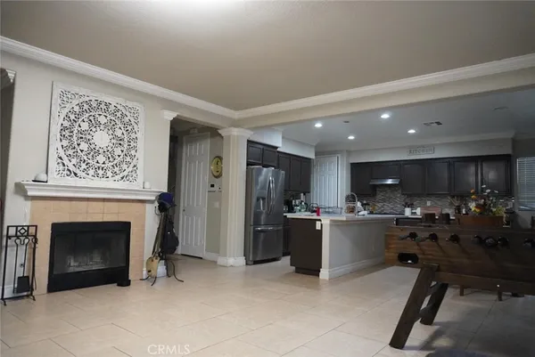a living room with stainless steel appliances kitchen island granite countertop furniture a fireplace and a window