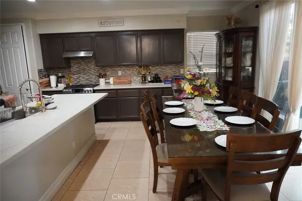 a kitchen with a dining table chairs and white cabinets