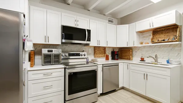 a kitchen with white cabinets stainless steel appliances and sink