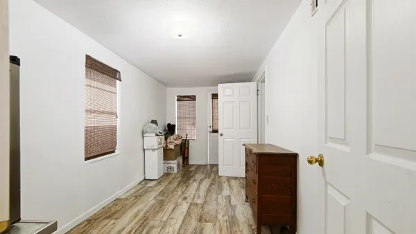 a view of a hallway with wooden floor and staircase