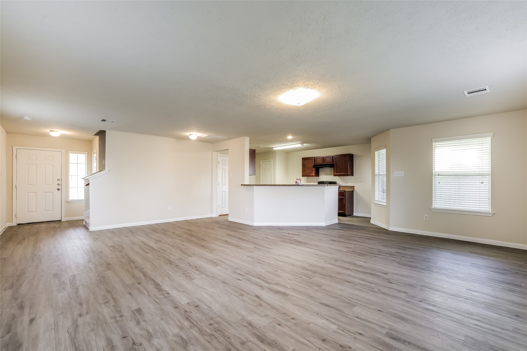14438 Acuna Lane Houston, TX 77045 - Photo 4 of 15 a view of empty room with wooden floor and kitchen