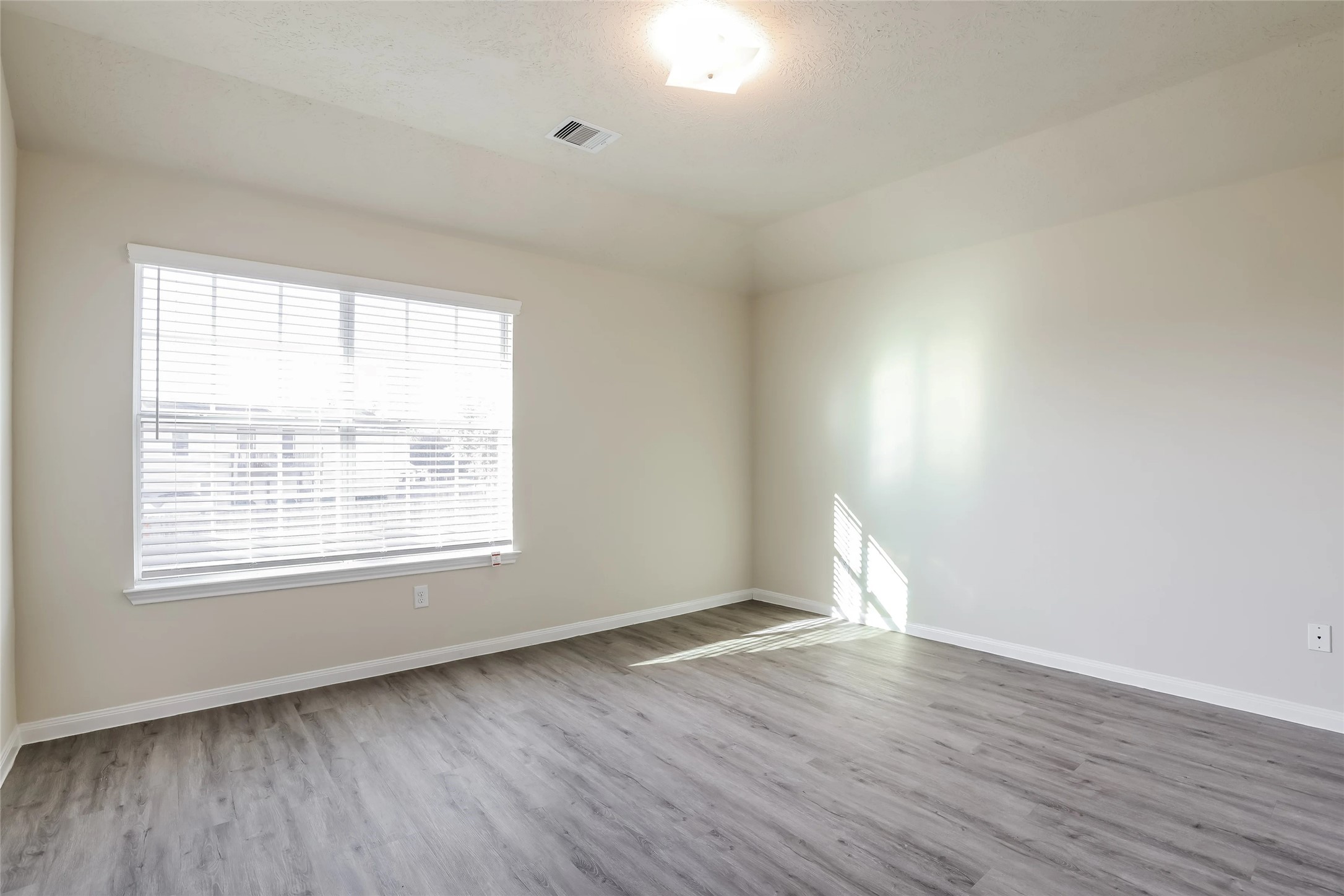 14438 Acuna Lane Houston, TX 77045 - Photo 6 of 15 an empty room with wooden floor and windows