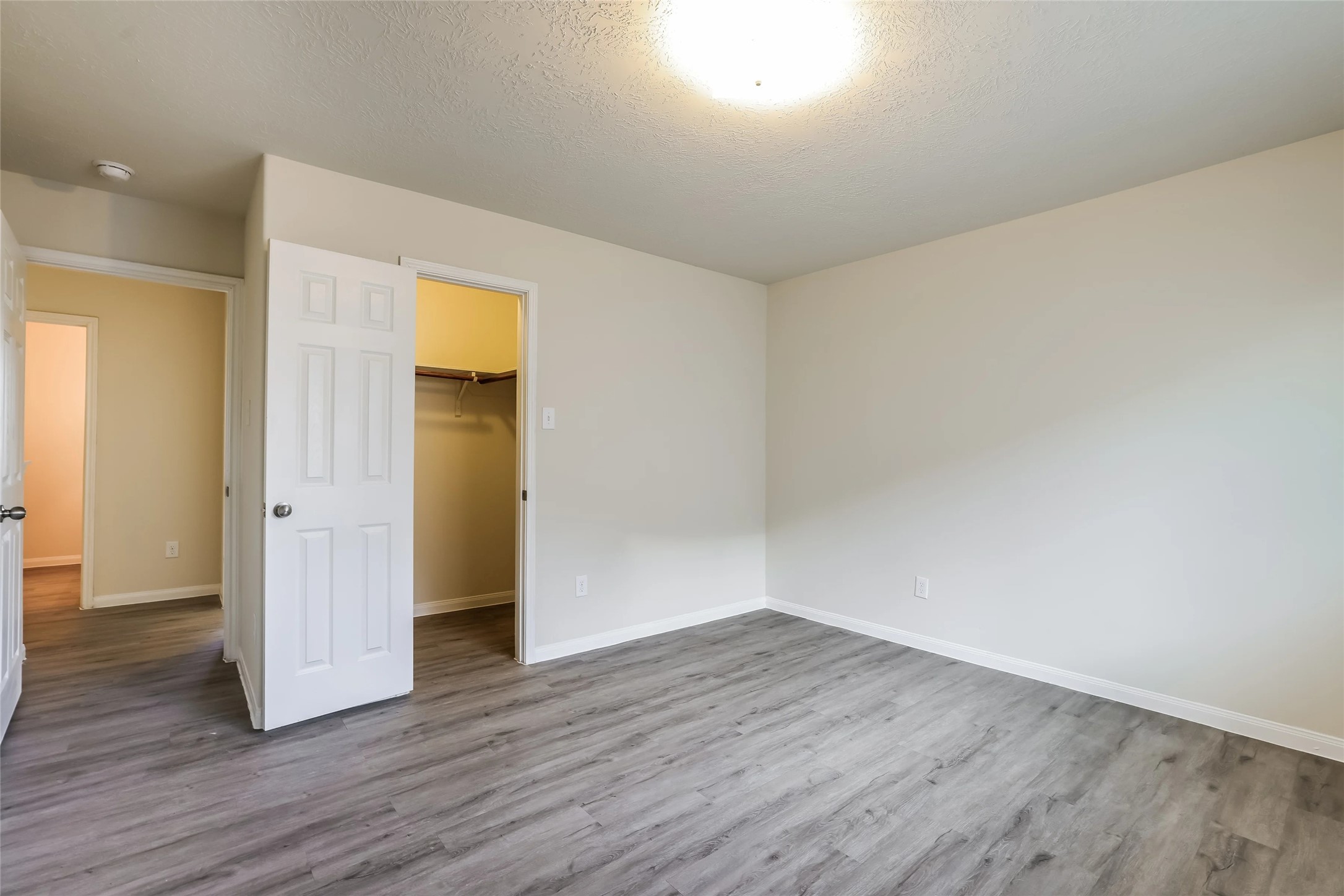 14438 Acuna Lane Houston, TX 77045 - Photo 8 of 15 an empty room with wooden floor and closet
