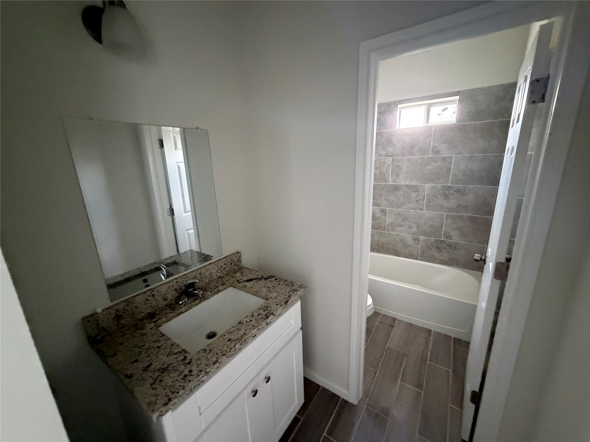 7952 Blue Street Houston, TX 77028 - Photo 11 of 14 a bathroom with a granite countertop sink and a mirror