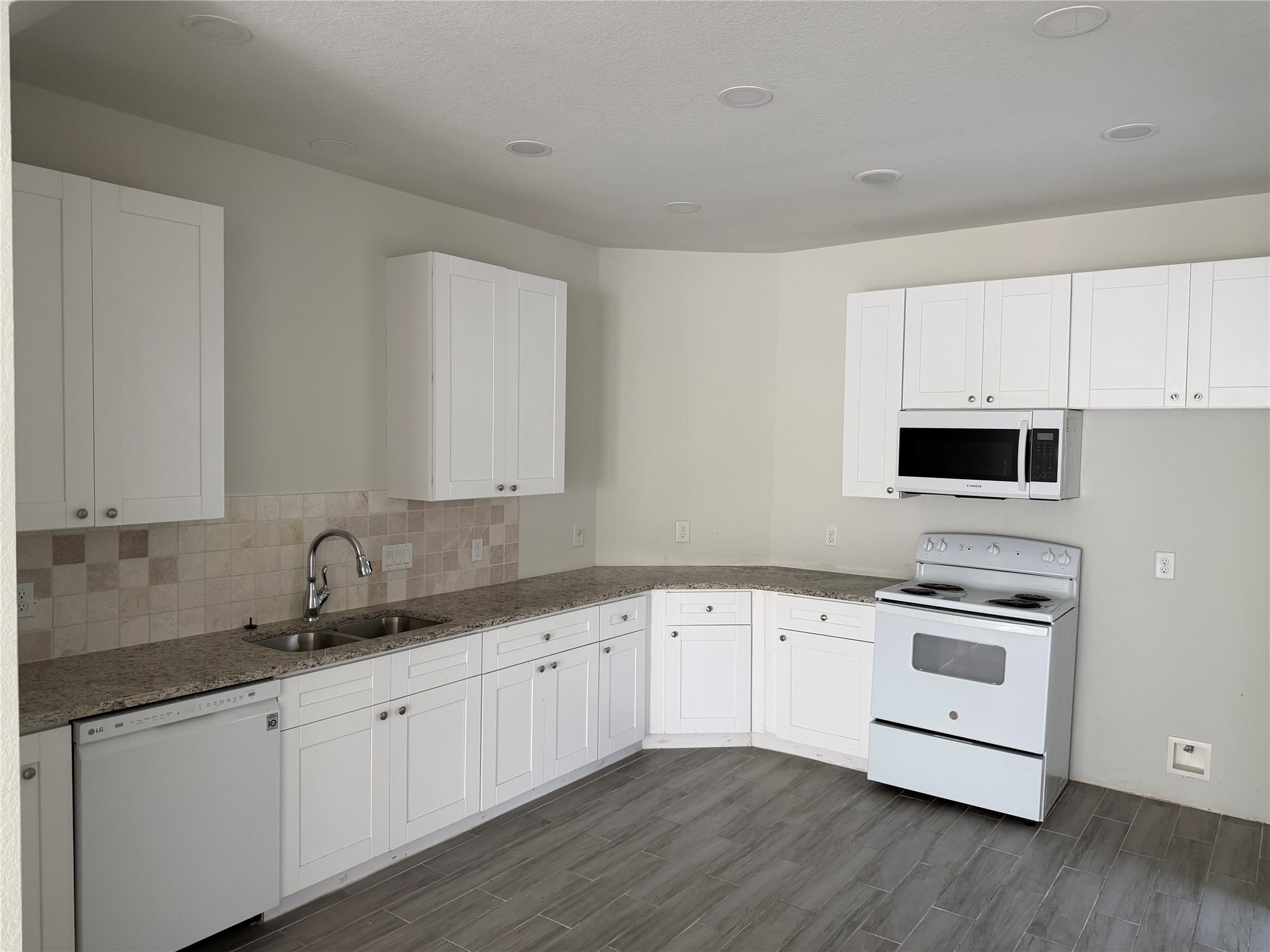 7952 Blue Street Houston, TX 77028 - Photo 4 of 14 a kitchen with granite countertop white cabinets and white appliances