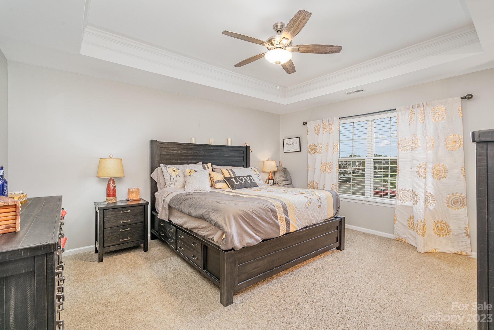 7572 Bluff Point Lane Denver, NC 28037 - Photo 19 of 33 a bedroom with a bed chandelier and a large window