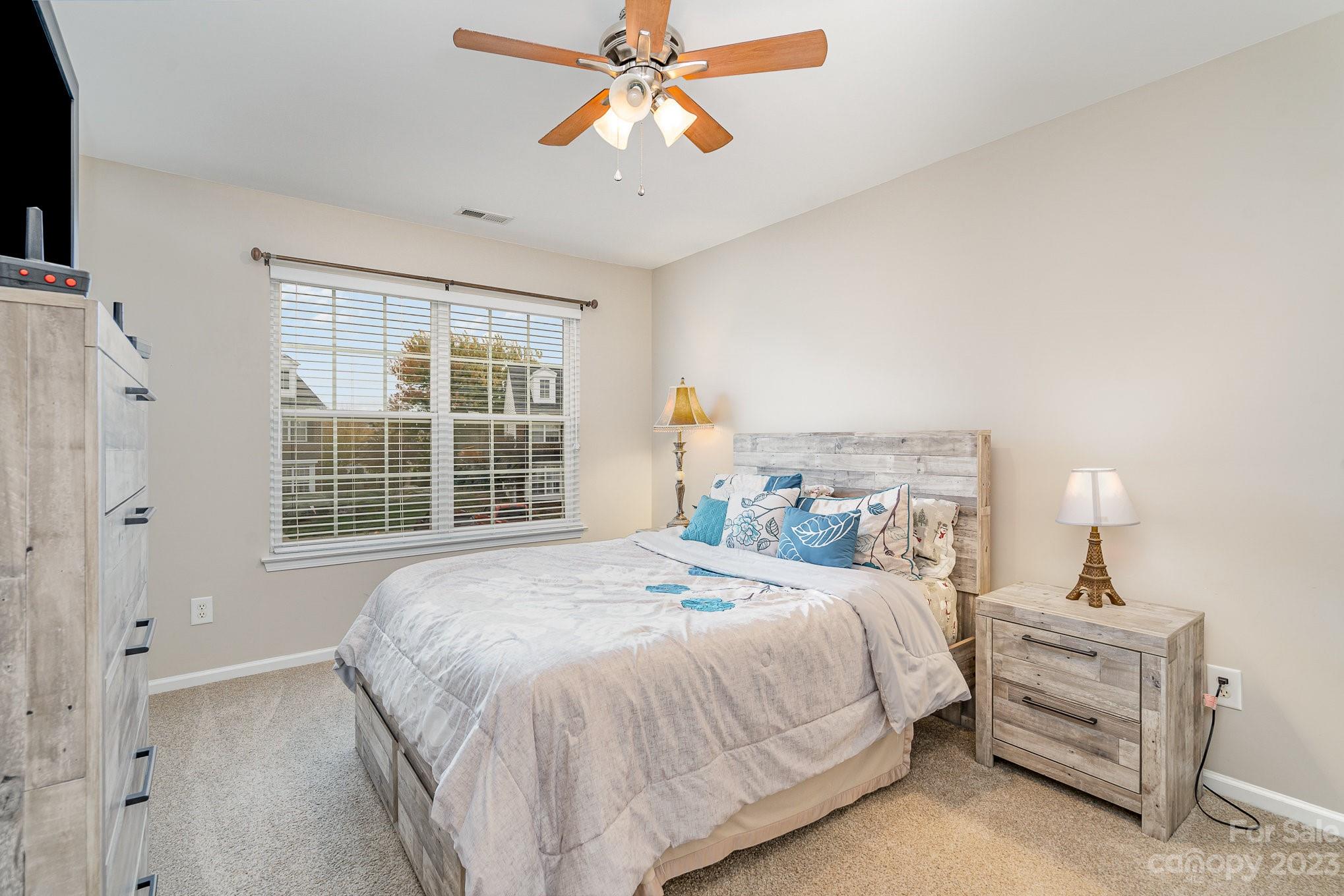 7572 Bluff Point Lane Denver, NC 28037 - Photo 24 of 33 a bedroom with a bed and a chandelier