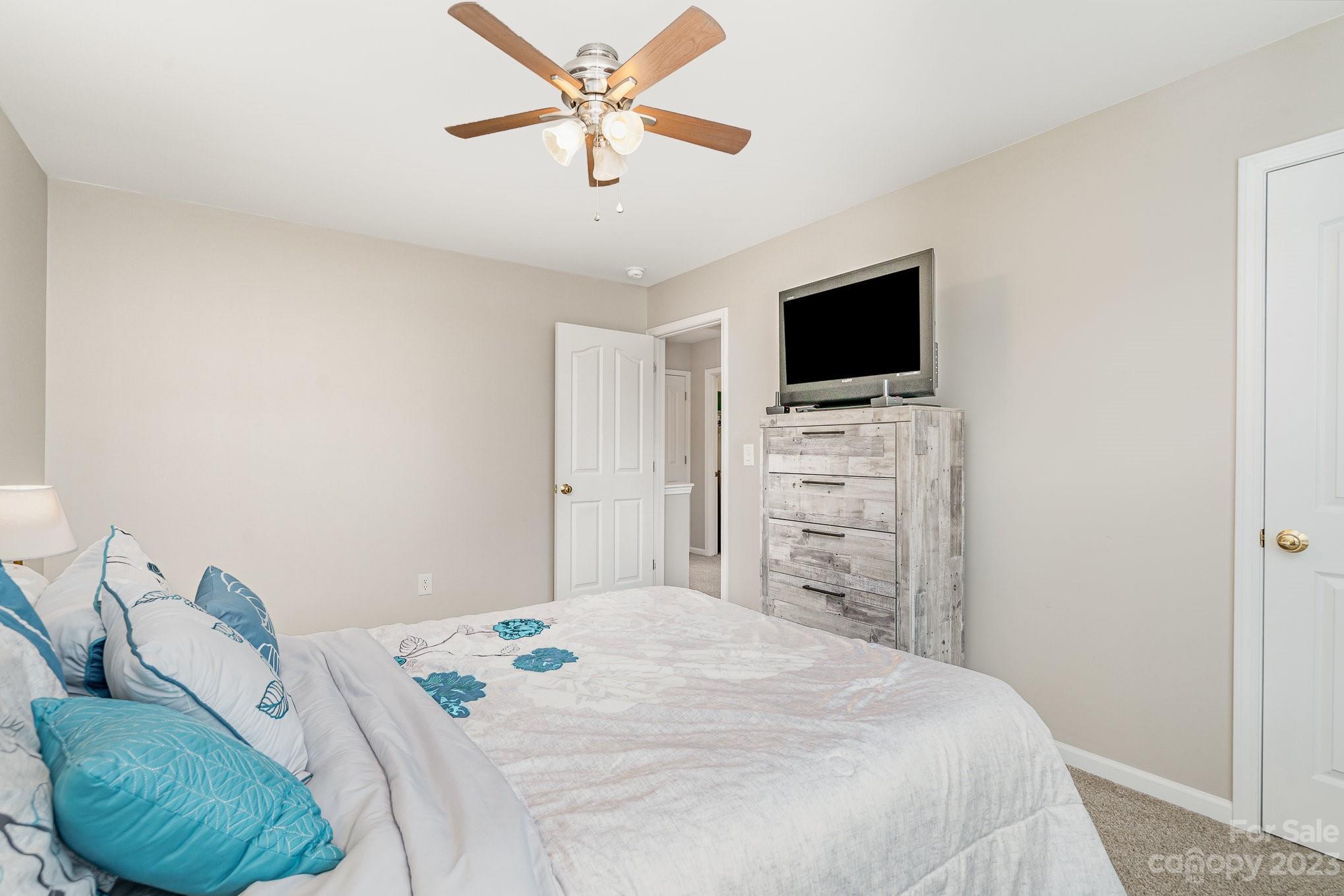 7572 Bluff Point Lane Denver, NC 28037 - Photo 25 of 33 a bedroom with a bed a flat screen tv and a couch