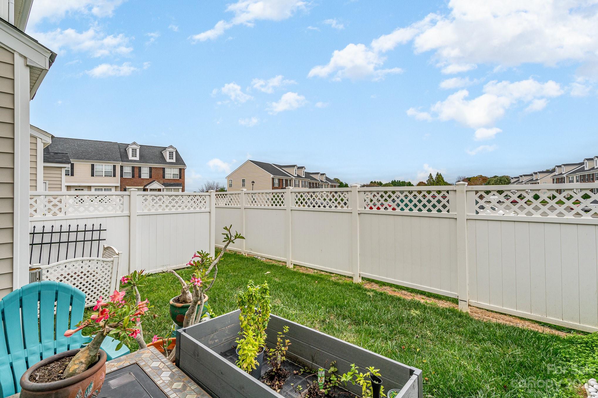 7572 Bluff Point Lane Denver, NC 28037 - Photo 33 of 33 a view of a city with flower plants and wooden fence