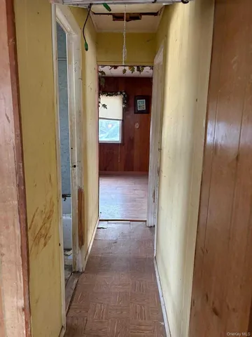 a view of hallway with a door and a fireplace
