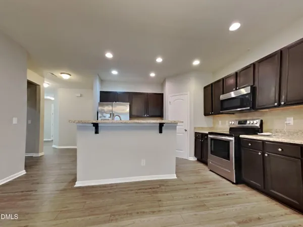 a view of kitchen with stainless steel appliances microwave refrigerator and stove