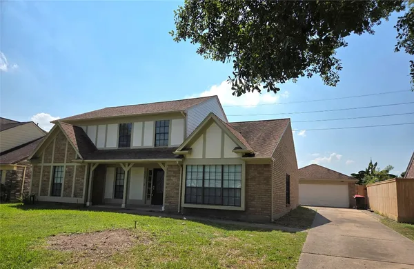 a view of a house with a yard and potted plants