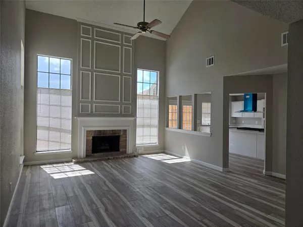 wooden floor fireplace and windows in an empty room