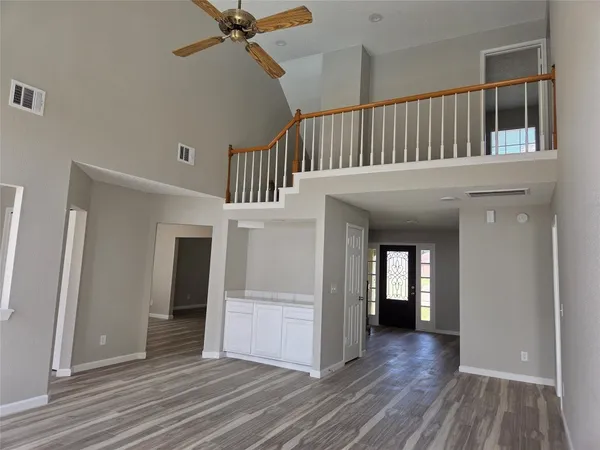 a view of a hallway with wooden floor and entryway