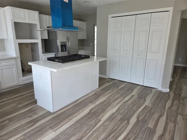 a kitchen with kitchen island a sink stove and refrigerator