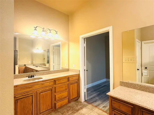 a spacious bathroom with a granite countertop sink and a mirror