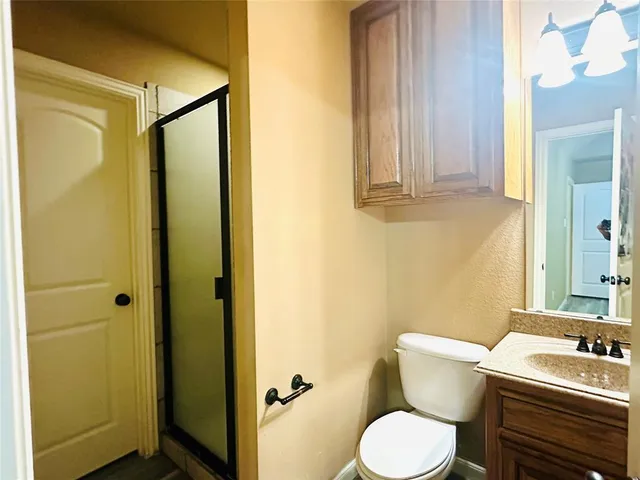 a bathroom with a toilet sink vanity and mirror