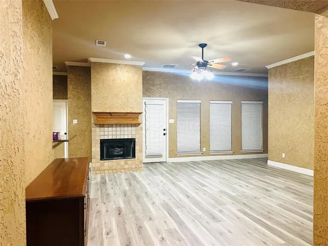 a view of a livingroom with a fireplace a chandelier and windows