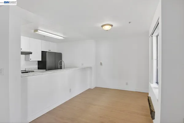a view of kitchen with stainless steel appliances wooden floor and window