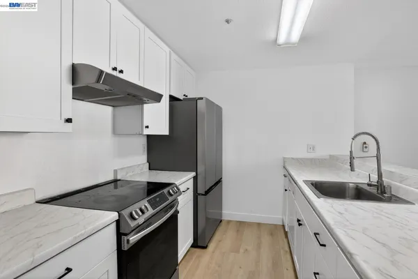 a kitchen with stainless steel appliances granite countertop a sink a stove and a refrigerator