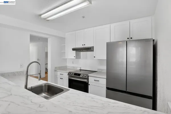 a kitchen with a refrigerator sink and cabinets