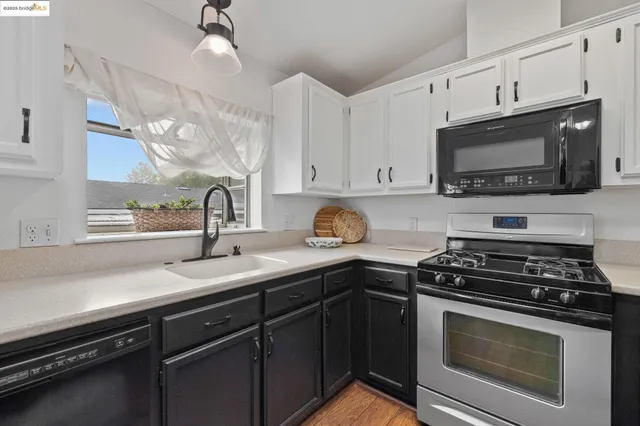 a kitchen with cabinets appliances a sink and a window