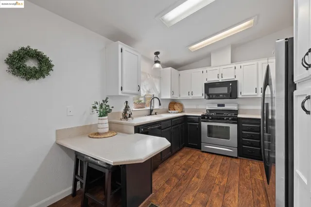 a kitchen with kitchen island a sink appliances and cabinets