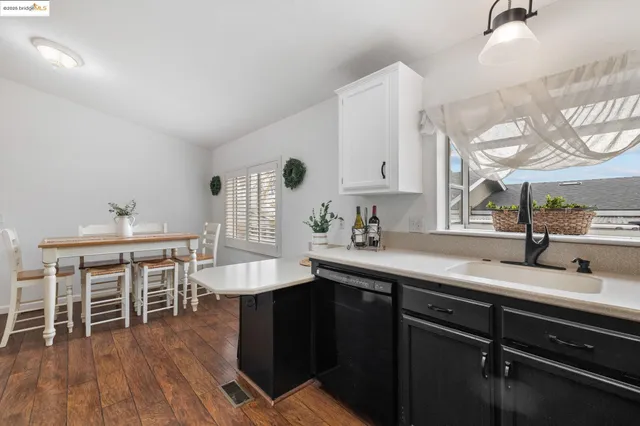 a kitchen with stainless steel appliances granite countertop a sink dishwasher and cabinets with wooden floor
