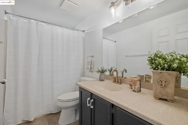 a bathroom with a granite countertop sink a toilet and a mirror