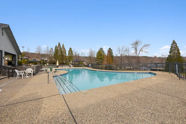 a view of swimming pool with outdoor seating and lake view