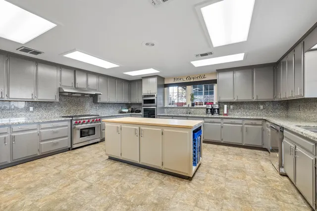 a kitchen with stainless steel appliances granite countertop a stove sink and cabinets