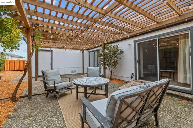 a patio with a table and chairs and potted plants