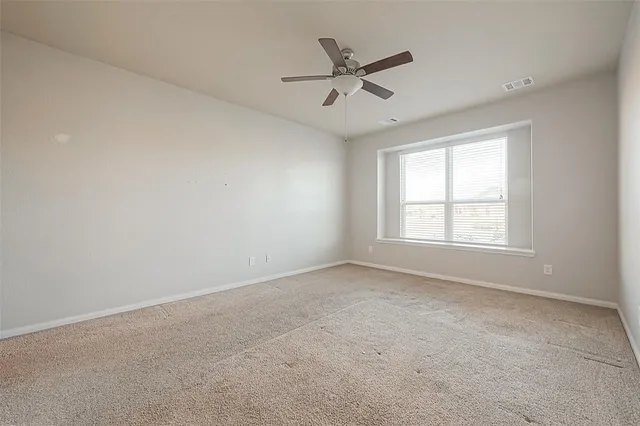 a spacious bedroom with a bed a chandelier and a potted plant