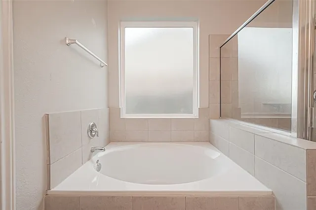 a bathroom with a tub shower and a sink