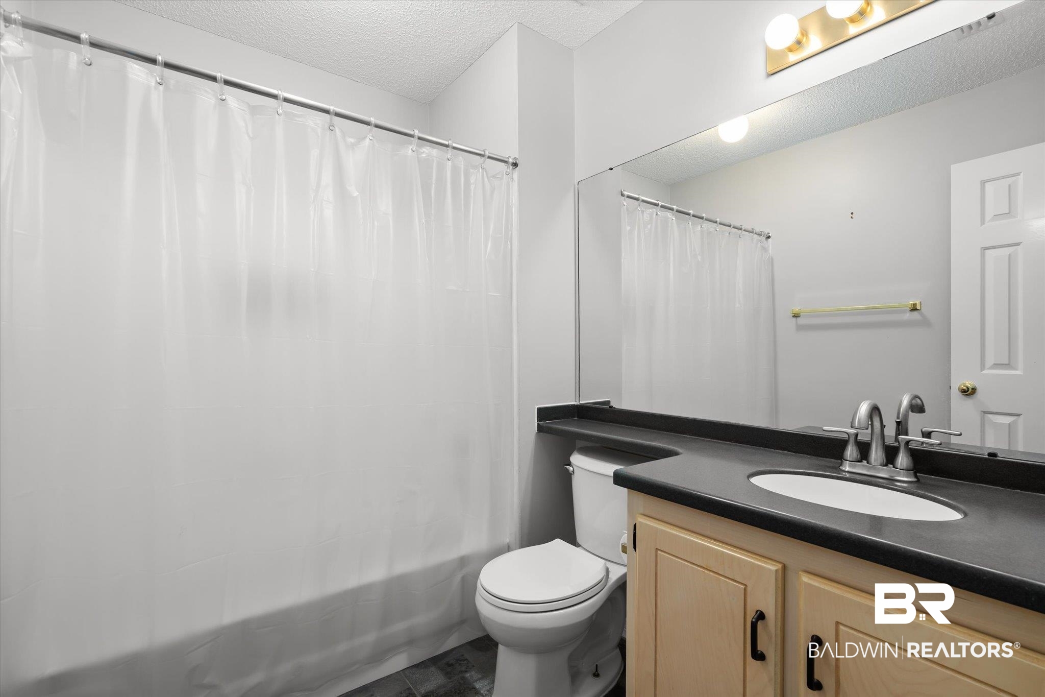 7410 East Lakeview Drive Mobile, AL 36695 - Photo 12 of 20 Full bathroom featuring vanity, toilet, shower / bath combo with shower curtain, and a textured ceiling