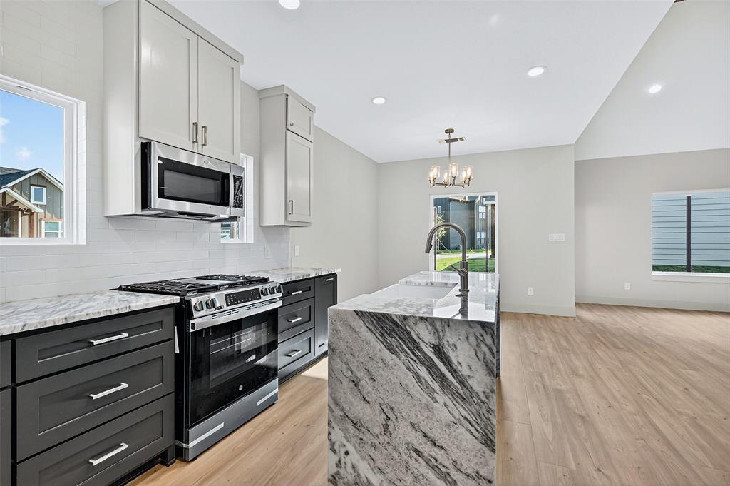 4805 Dry Creek Road Sherman, TX 75092 - Photo 11 of 29 a kitchen with granite countertop wooden cabinets and stainless steel appliances